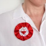kokarda-narodowa-duz-serca-445 kobieta z kotylionym biało-czerwonym z naklejonym sercem